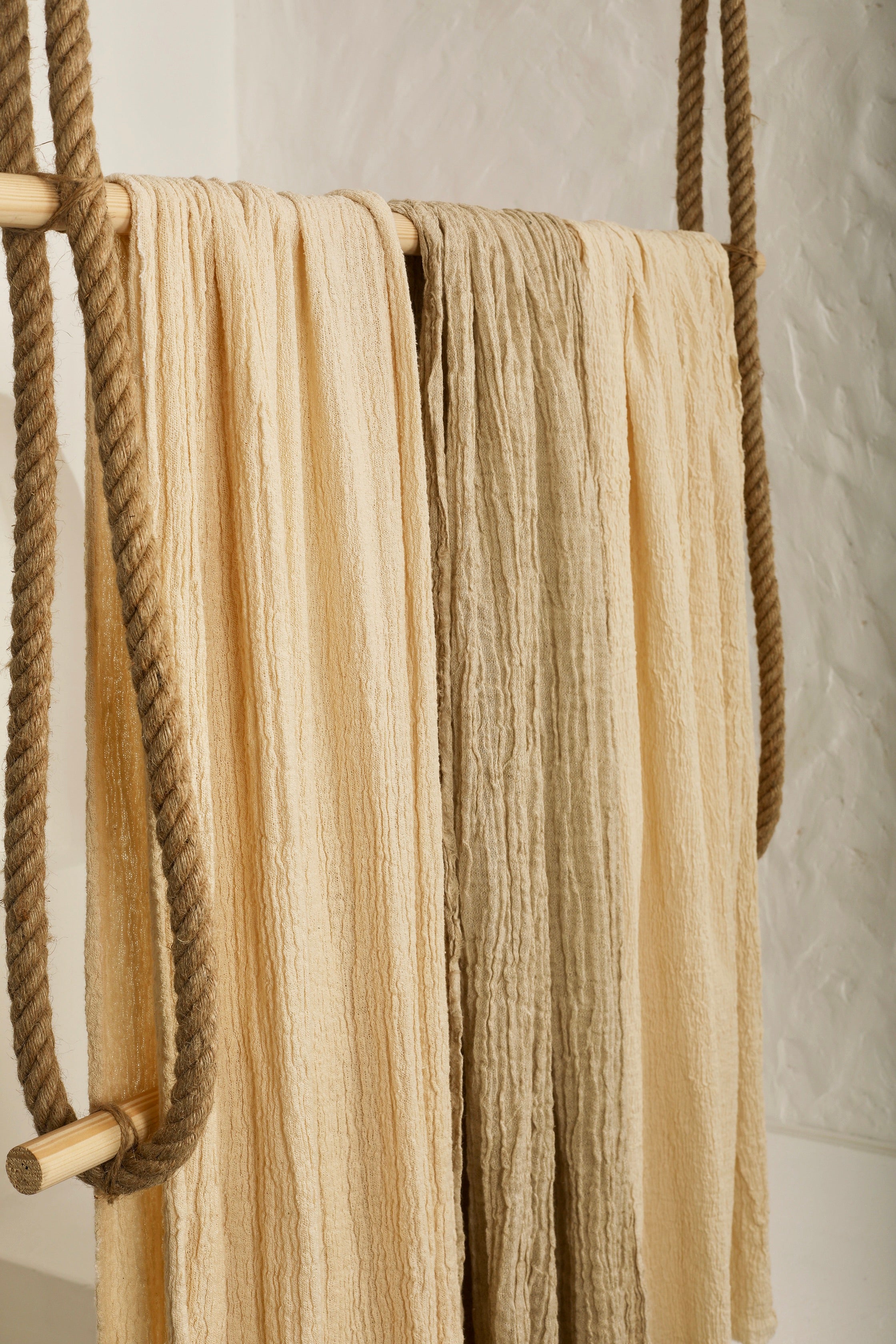 Tissu en coton froissé extensible neutre, surface texturée, coton tissé à la main blanc cassé, coton beige biologique semi-transparent et non blanchi.
