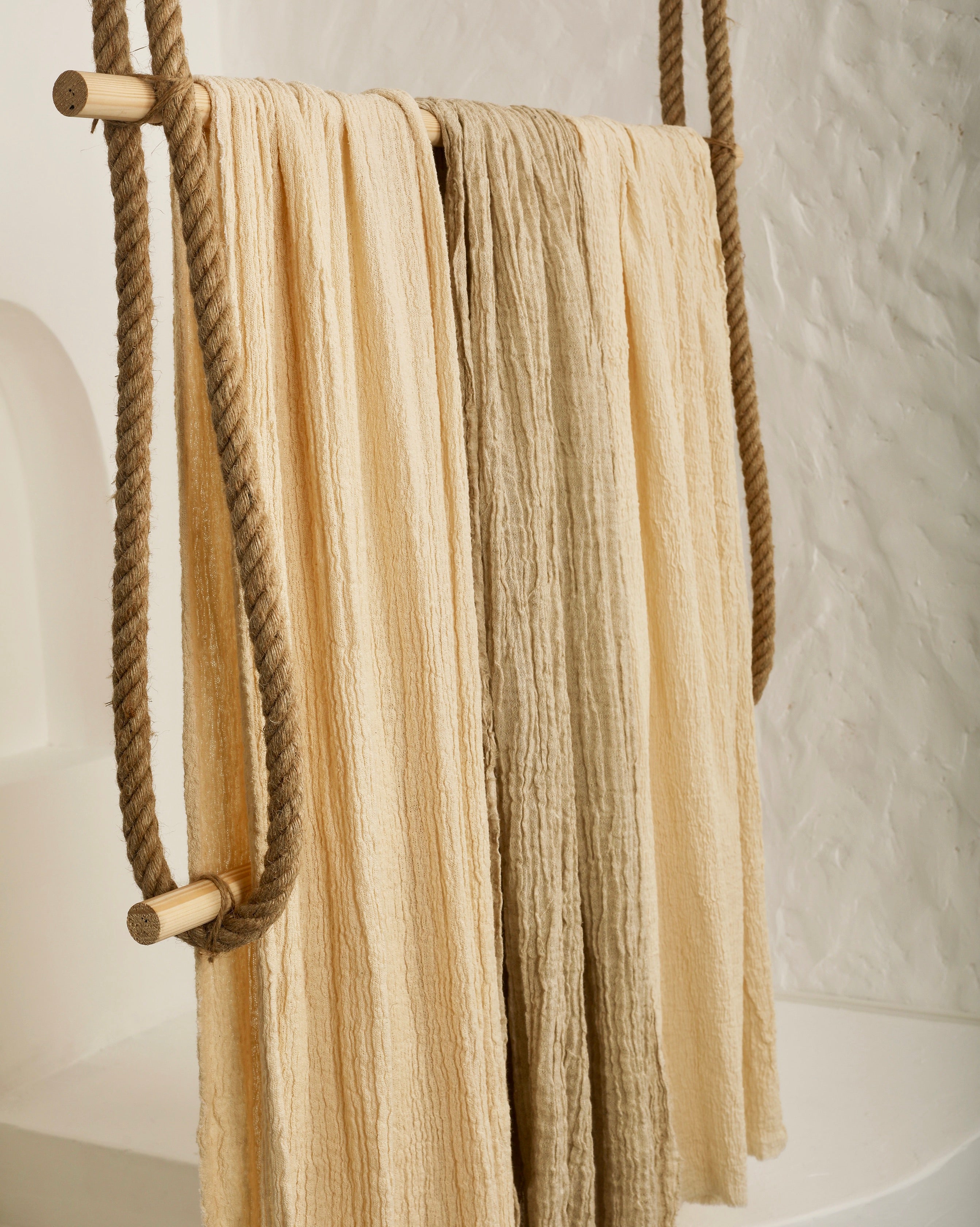 Tissu en coton froissé extensible neutre, surface texturée, coton tissé à la main blanc cassé, coton beige biologique semi-transparent et non blanchi.