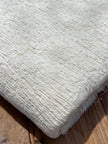 Tissu en coton froissé extensible neutre, surface texturée, coton tissé à la main blanc cassé, coton beige biologique semi-transparent et non blanchi.