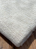 Tissu en coton froissé extensible neutre, surface texturée, coton tissé à la main blanc cassé, coton beige biologique semi-transparent et non blanchi.