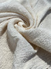 Tissu en coton froissé extensible neutre, surface texturée, coton tissé à la main blanc cassé, coton beige biologique semi-transparent et non blanchi.