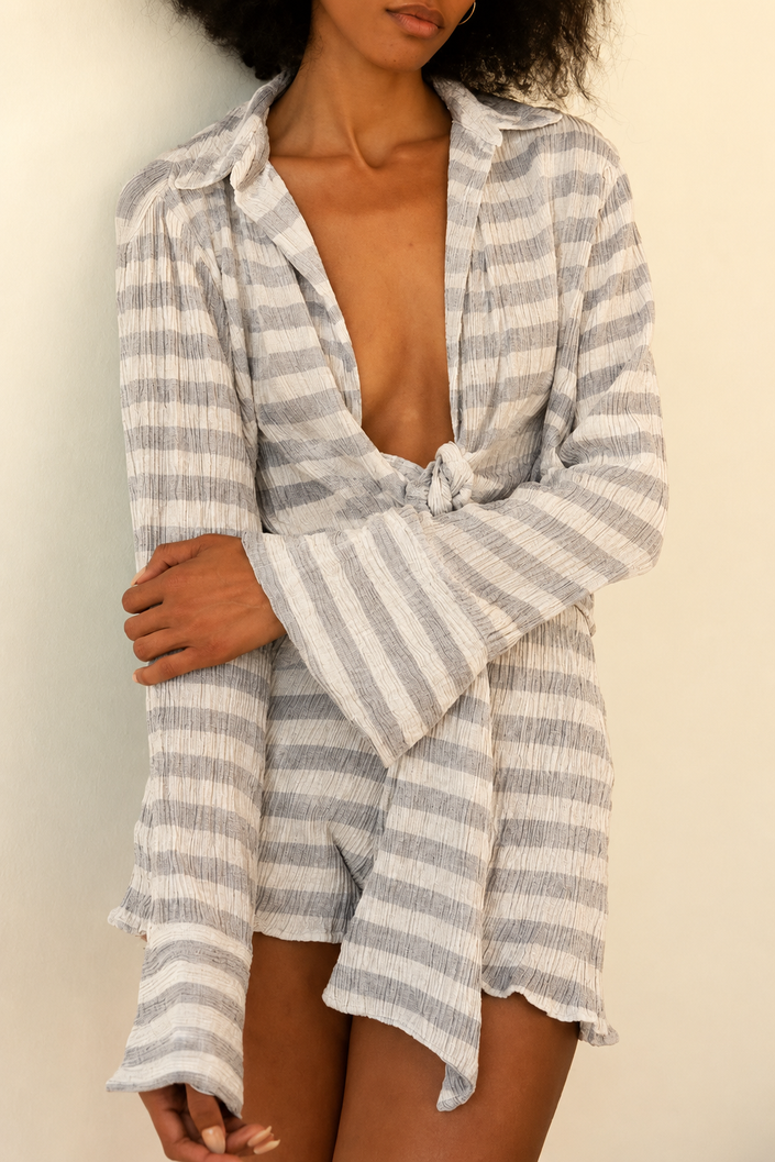 Woman wearing a striped cover-up against a neutral background