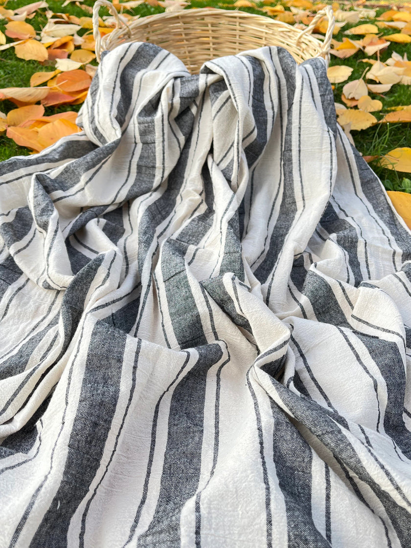 Tissu naturel en gaze de coton à rayures noires.