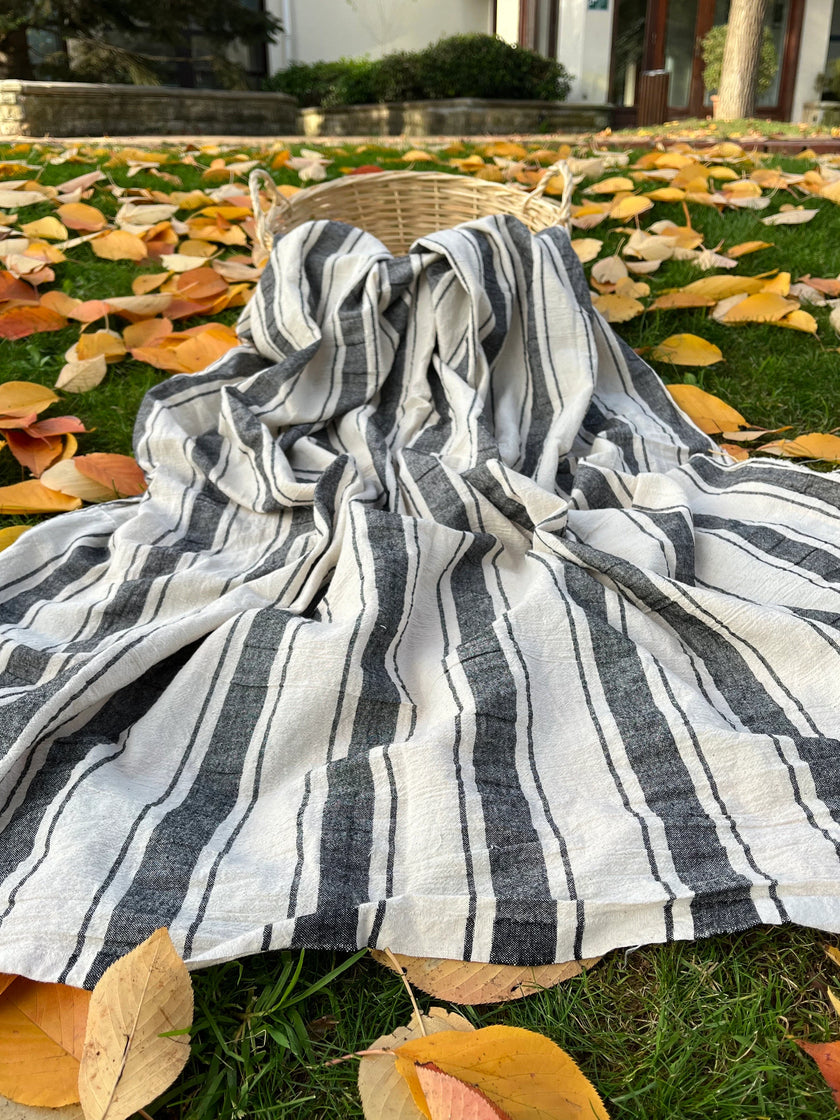 Tissu naturel en gaze de coton à rayures noires.