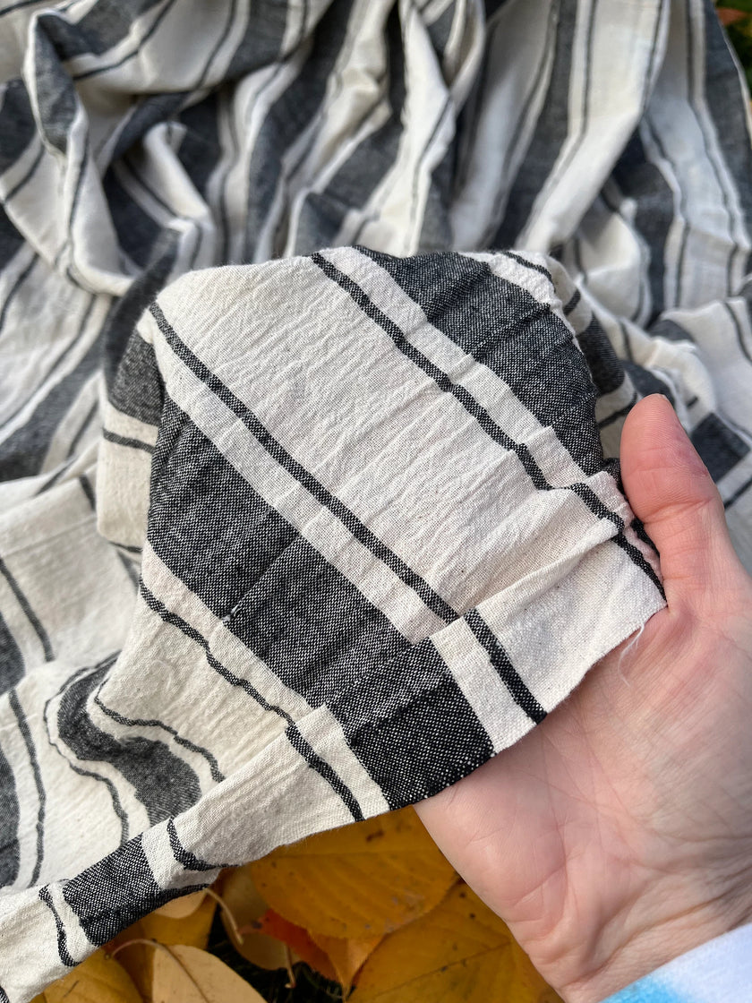 Tissu naturel en gaze de coton à rayures noires.