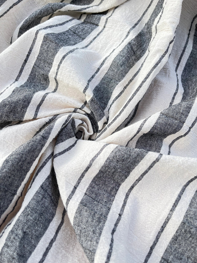 Tissu naturel en gaze de coton à rayures noires.