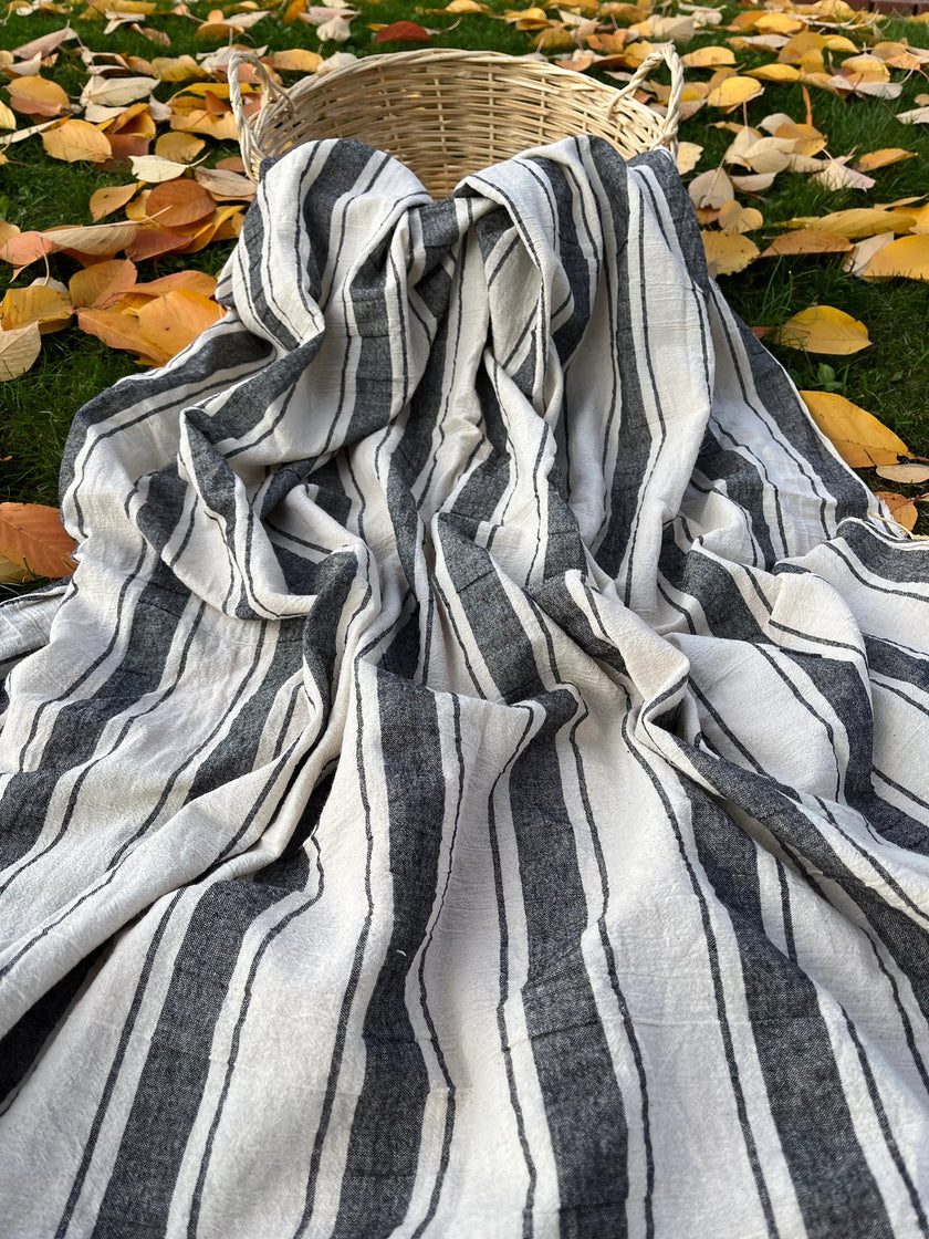 Tissu naturel en gaze de coton à rayures noires.