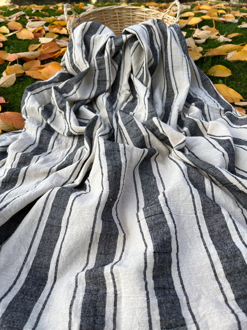 Tissu naturel en gaze de coton à rayures noires.